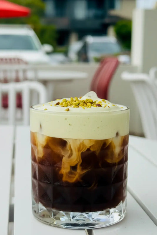 Raza Pistachio Iced Coffee with pale green pistachio cold foam and crushed pistachio garnish